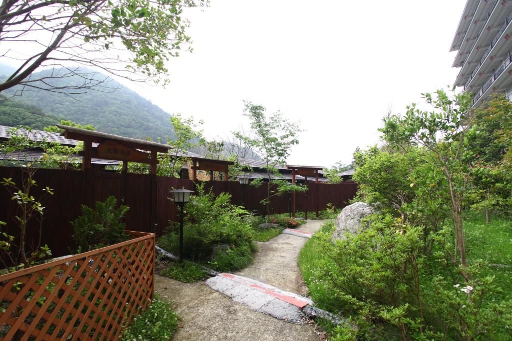 un jardin avec une clôture et une montagne en arrière-plan dans l'établissement Shiobara Onsen Hotel Ohruri, à Nasushiobara