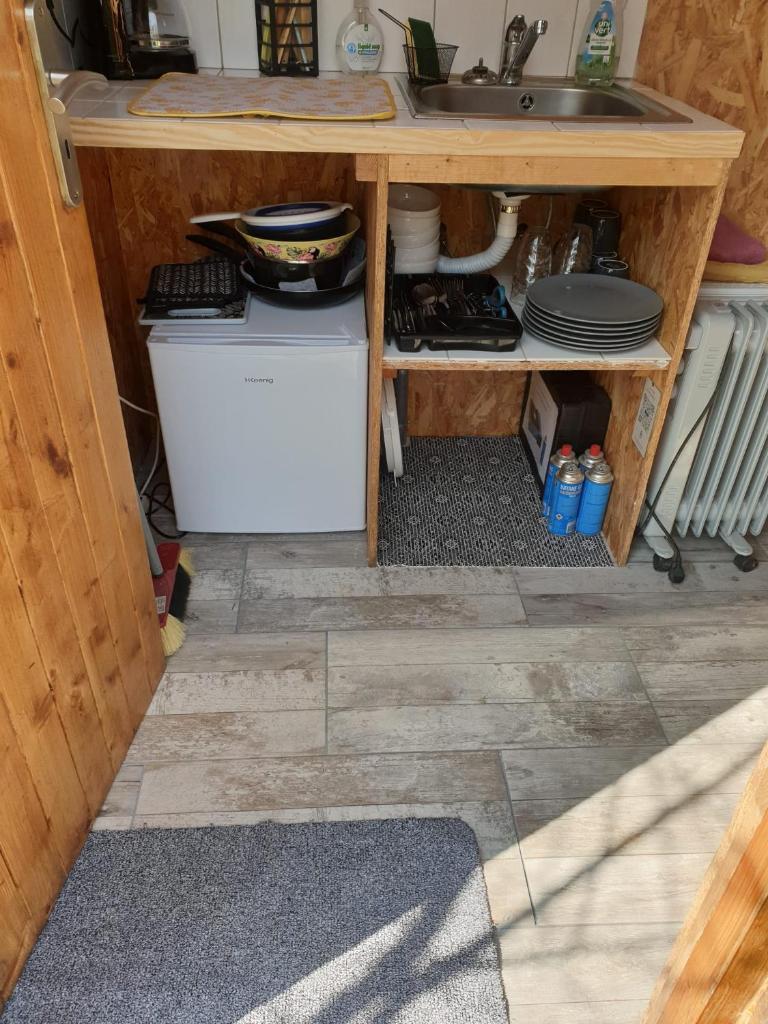 une cuisine avec un évier et un comptoir avec de la vaisselle dans l'établissement Yourtes 6 personnes proche provins et disney, à Bannost