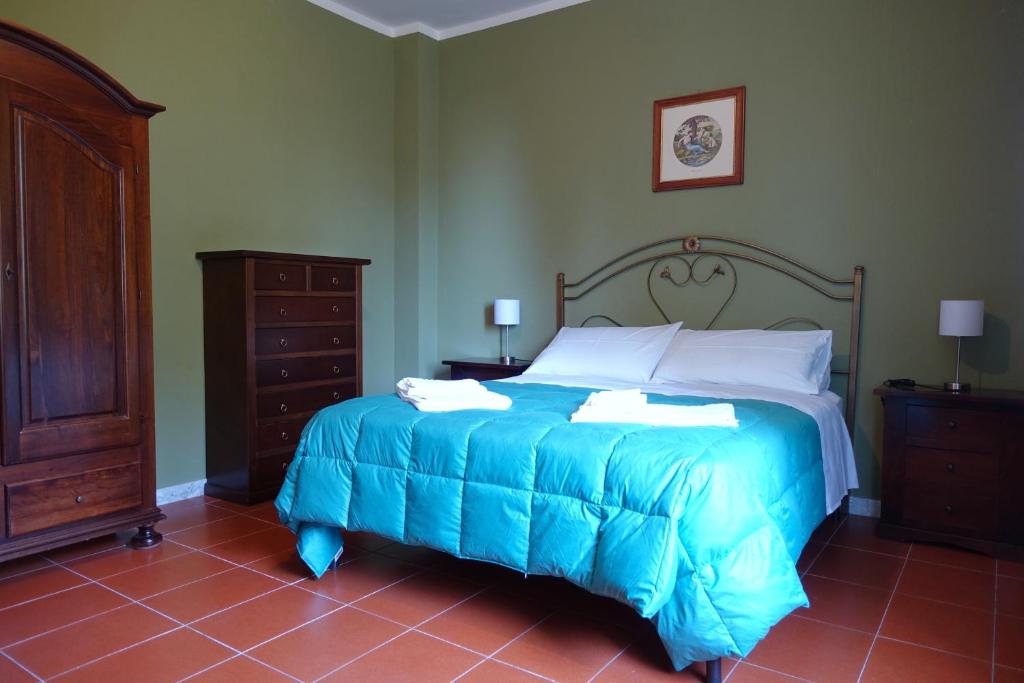 une chambre avec un lit avec une couette bleue dans l'établissement Villa Solaria, à Santa Venerina