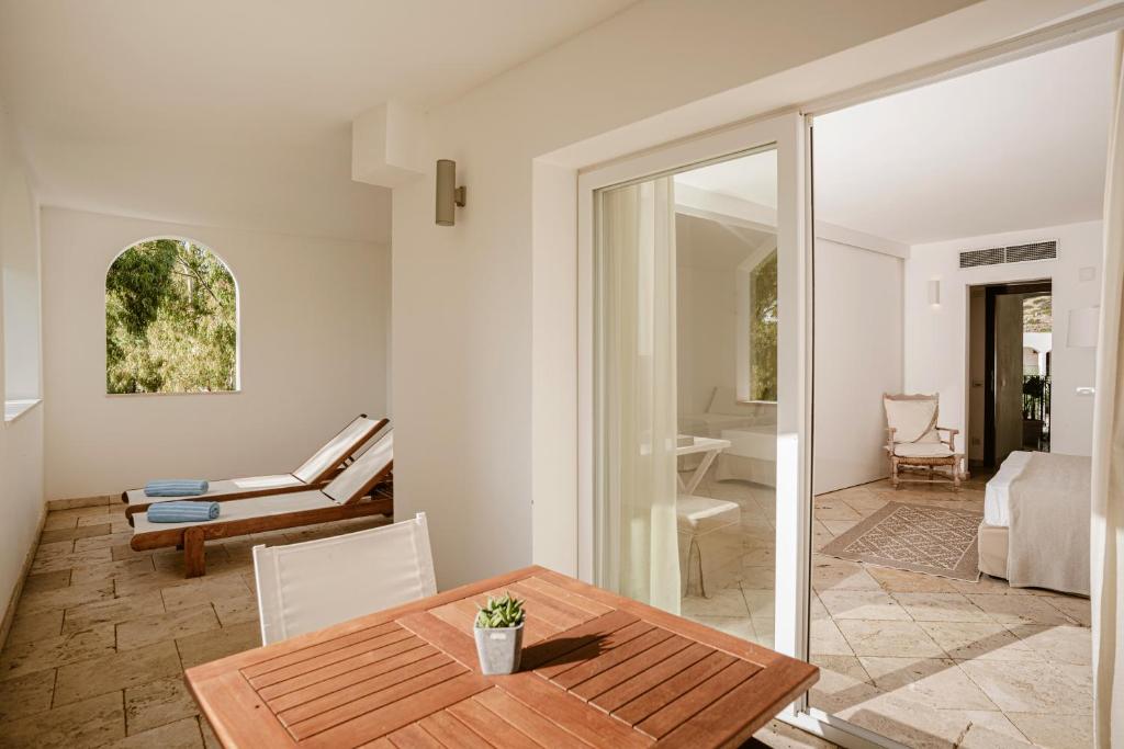 une salle à manger avec une table et un salon dans l'établissement Falkensteiner Resort Capo Boi, à Villasimius