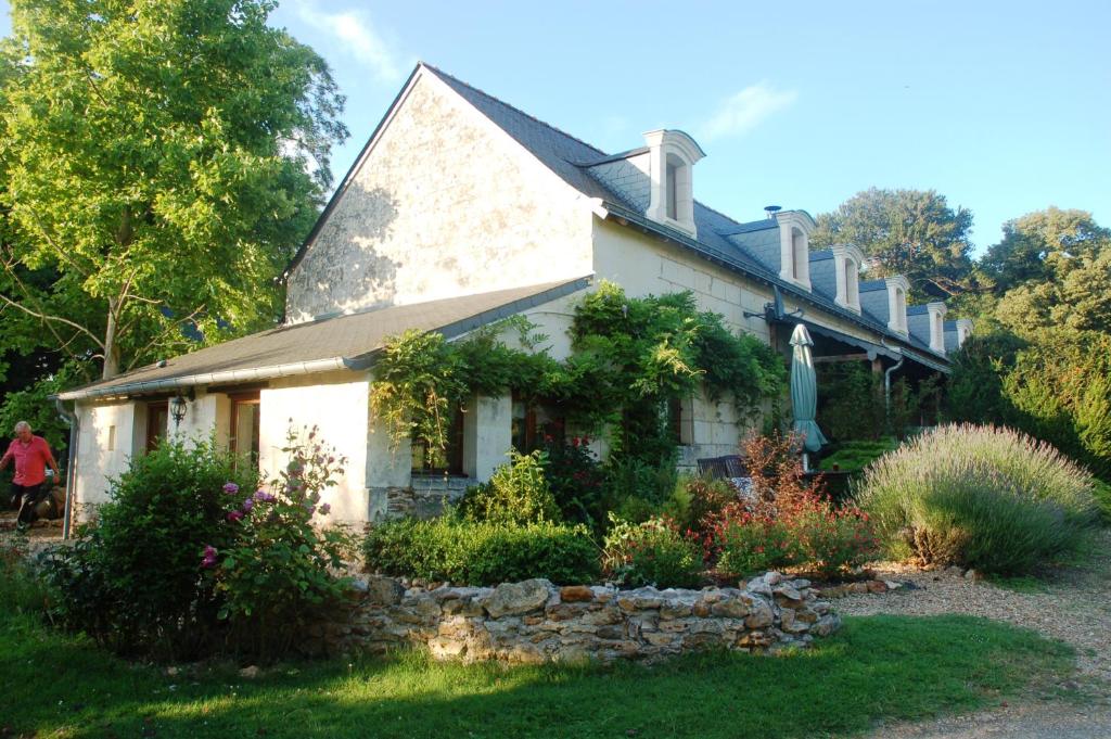 une maison blanche avec un jardin en face dans l'établissement Le Logis du Pressoir Self Catering Gites in beautiful 18th Century Estate in the heart of the Loire Valley with heated pool and extensive grounds., à Brion