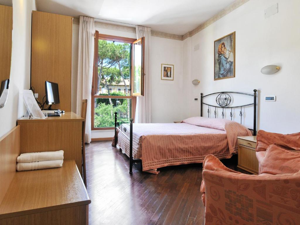 une chambre avec un lit, une chaise et une fenêtre dans l'établissement Albergo Bice, à Senigallia