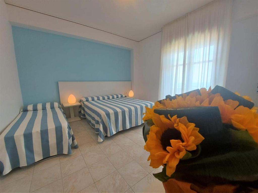 Cette chambre comprend 2 lits avec des tournesols au milieu. dans l'établissement Hotel Il Gabbiano Beach, à Terme Vigliatore 72 autres photos