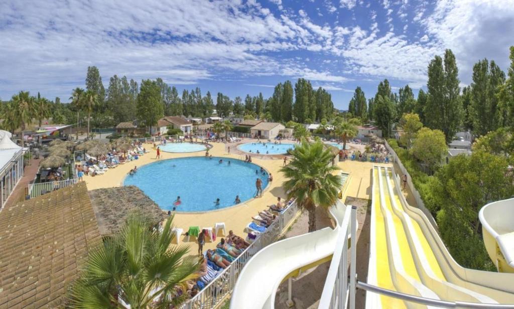 - une vue sur la piscine d'un complexe dans l'établissement Frejus tout confort, climatisation,plus ventilation toutes les chambres, linge de lit et de toilette , coffre fort, lavé vaisselle machine à laver grande terrasse couverte velos et wifi possible, à Fréjus