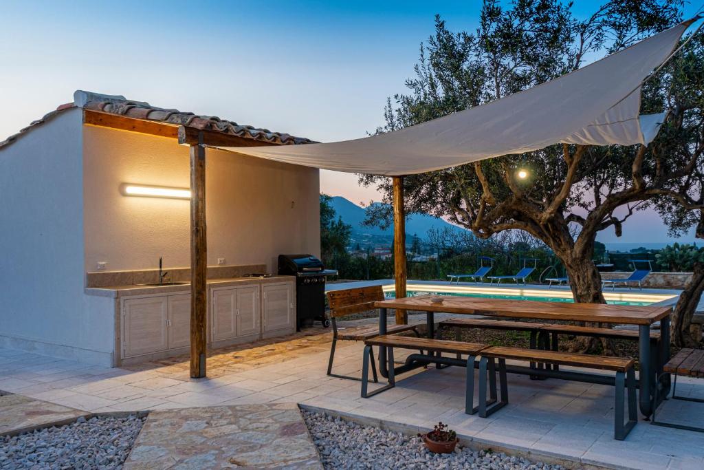 - un pavillon avec une table de pique-nique et un banc de pique-nique dans l'établissement Scialari Country House, à Castellammare del Golfo