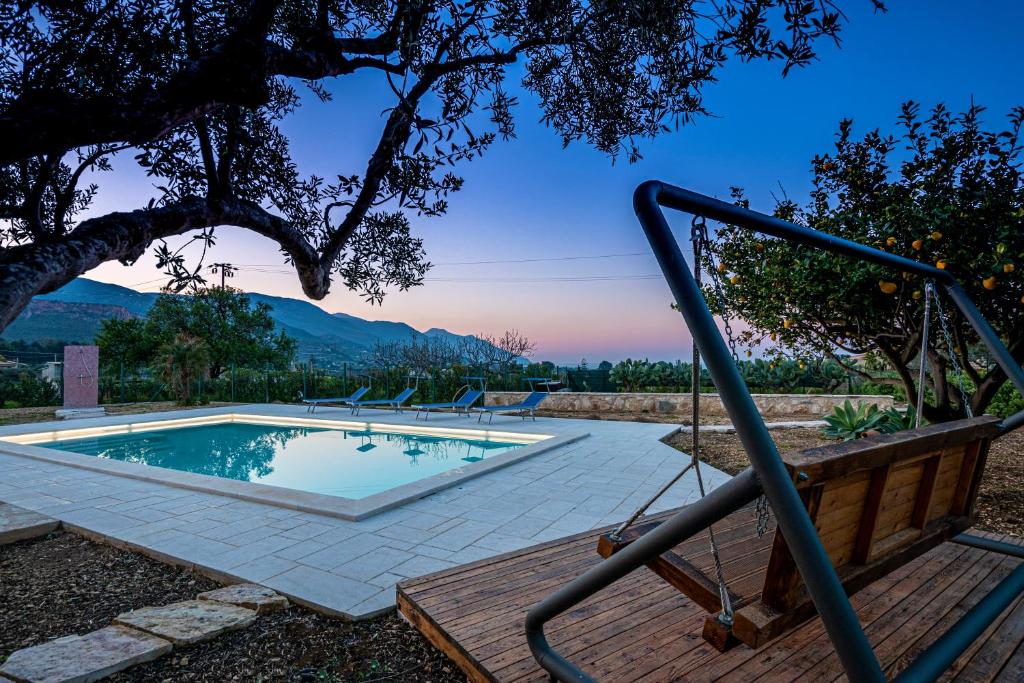 - une piscine avec des chaises et une balançoire dans l'établissement Scialari Country House, à Castellammare del Golfo