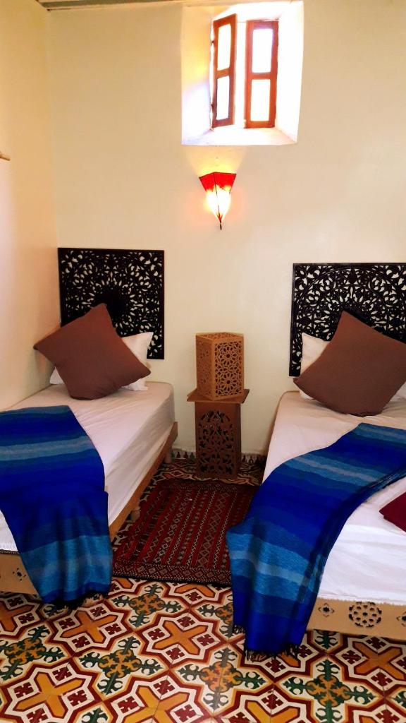 une chambre avec deux lits et une fenêtre dans l'établissement Dar nadaa, à Fès