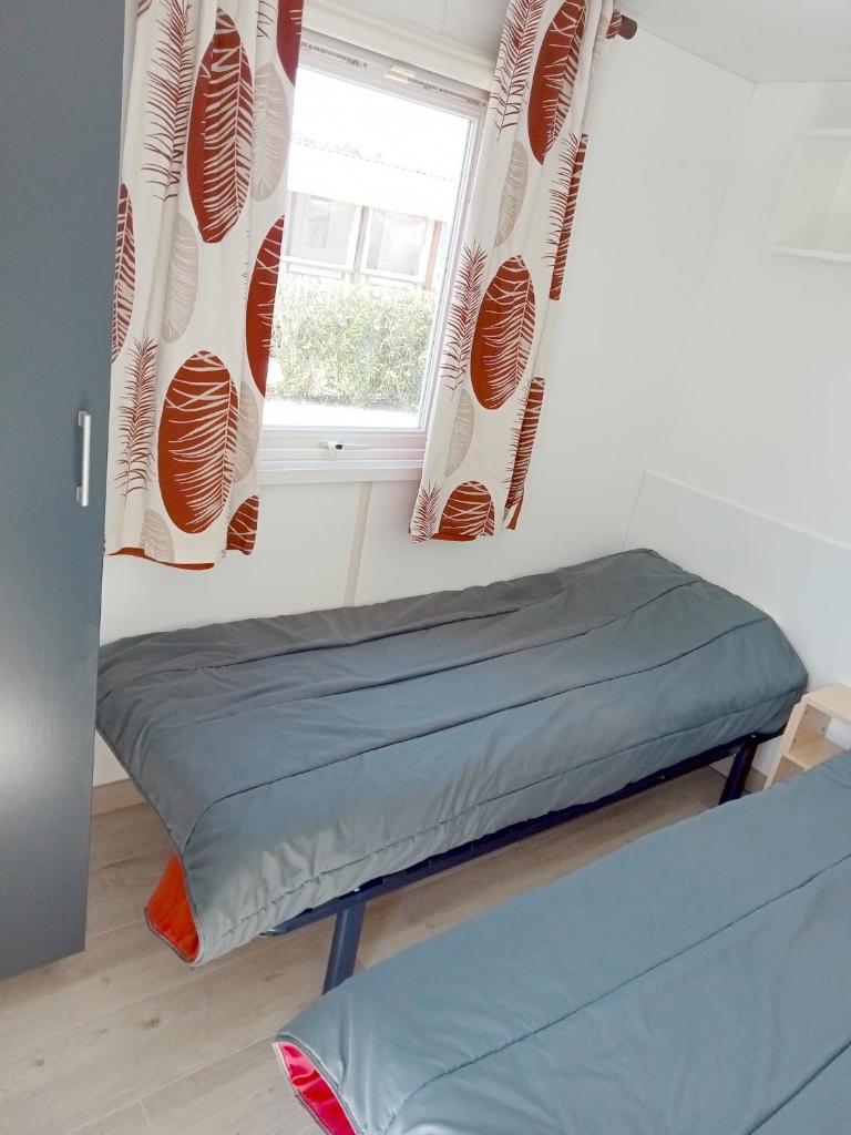 Cette chambre comprend un lit et une fenêtre. dans l'établissement Spacieux Mobil-Home Fréjus, à Fréjus