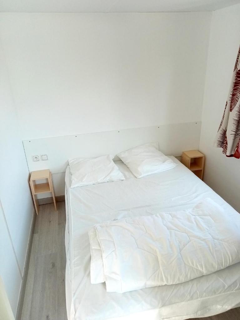 - un lit blanc dans une chambre aux murs blancs dans l'établissement Spacieux Mobil-Home Fréjus, à Fréjus 8 autres photos