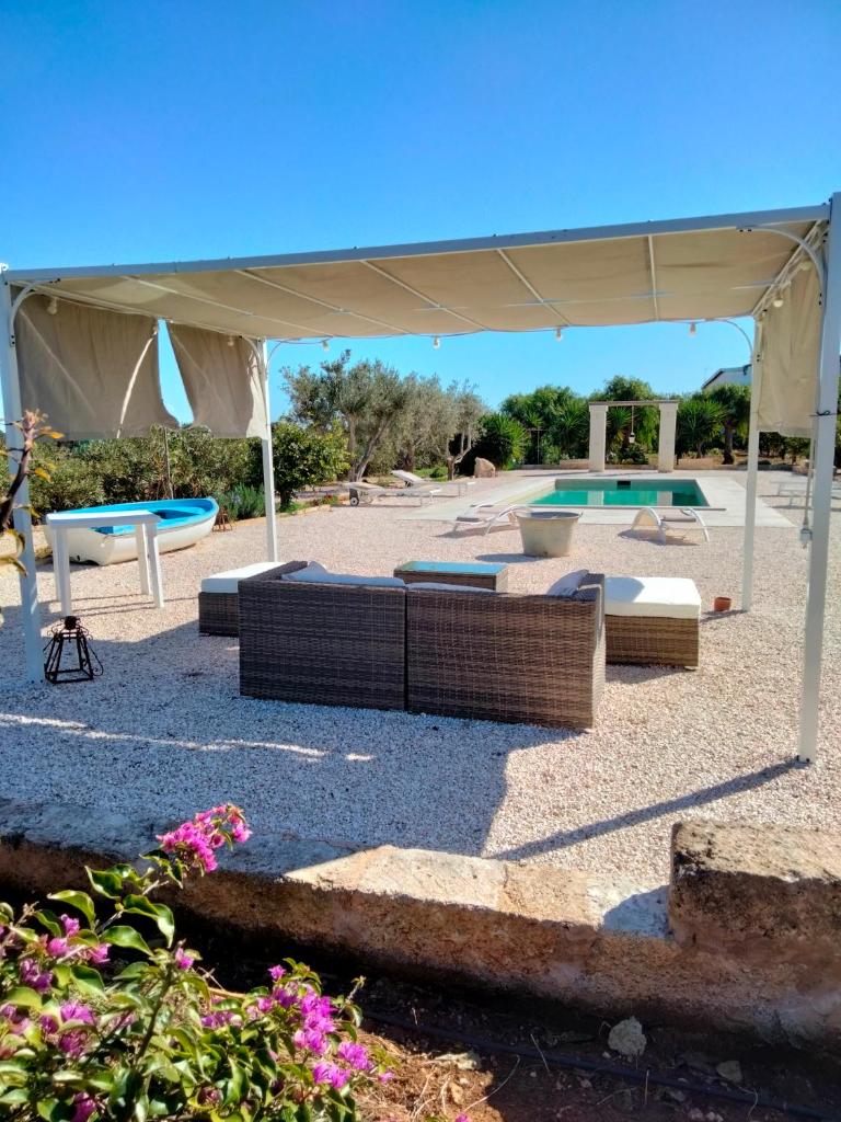 un patio avec un auvent et une piscine dans l'établissement Le Casette fra le Masserie, à Fasano 61 autres photos