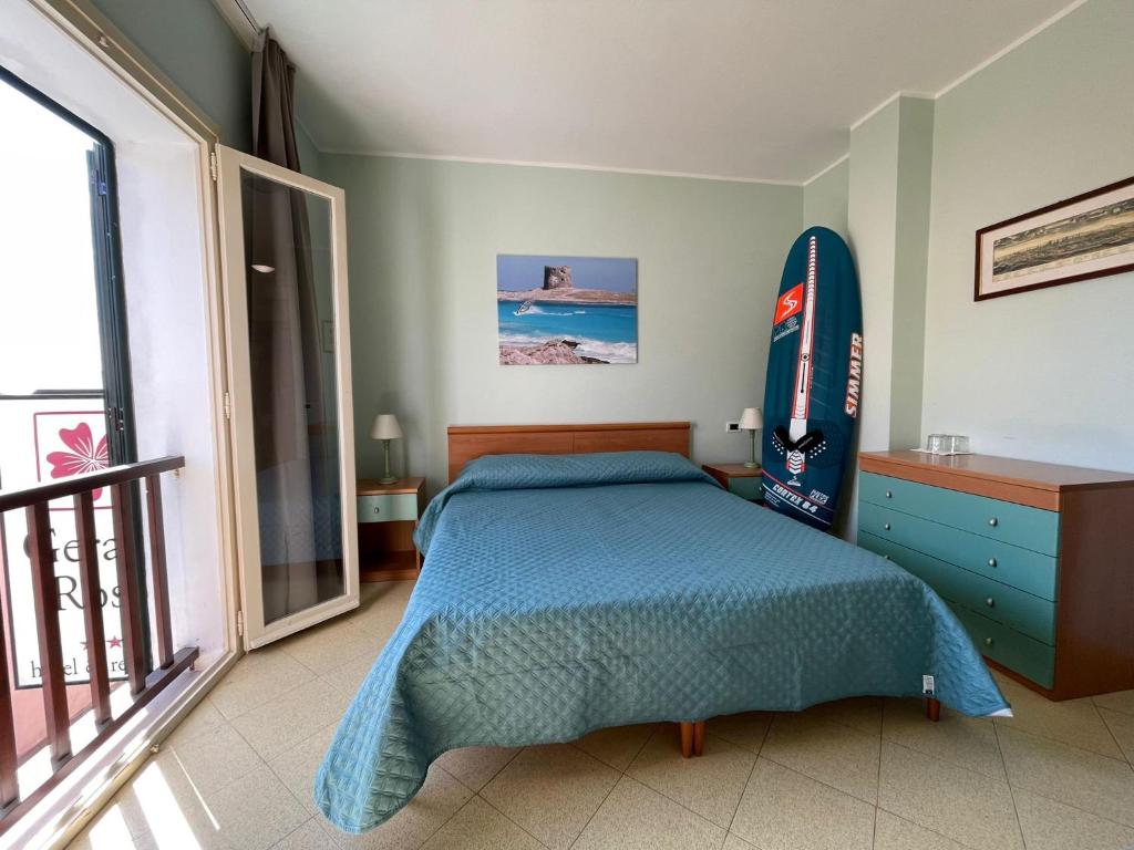 - une chambre avec un lit et une planche de surf sur le mur dans l'établissement Hotel Geranio Rosso, à Stintino