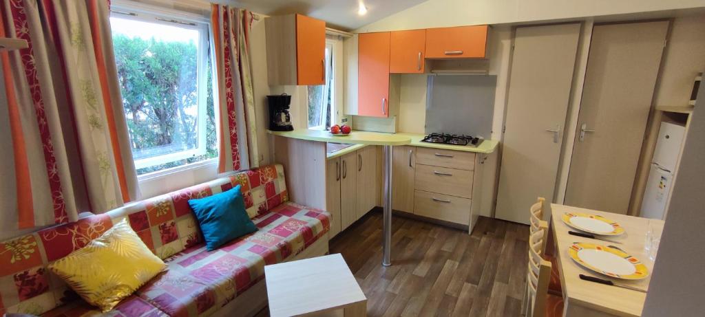 un salon avec un canapé et une cuisine dans l'établissement Mobil home 6 places, à La Roque-dʼAnthéron
