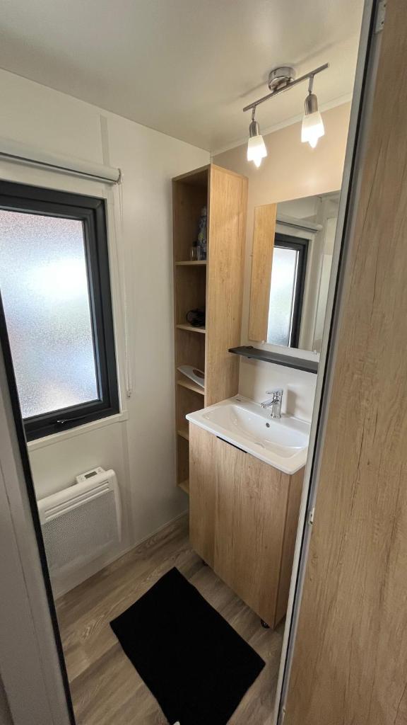 une salle de bain avec un lavabo et un miroir dans l'établissement Bayaïna, à Gastes