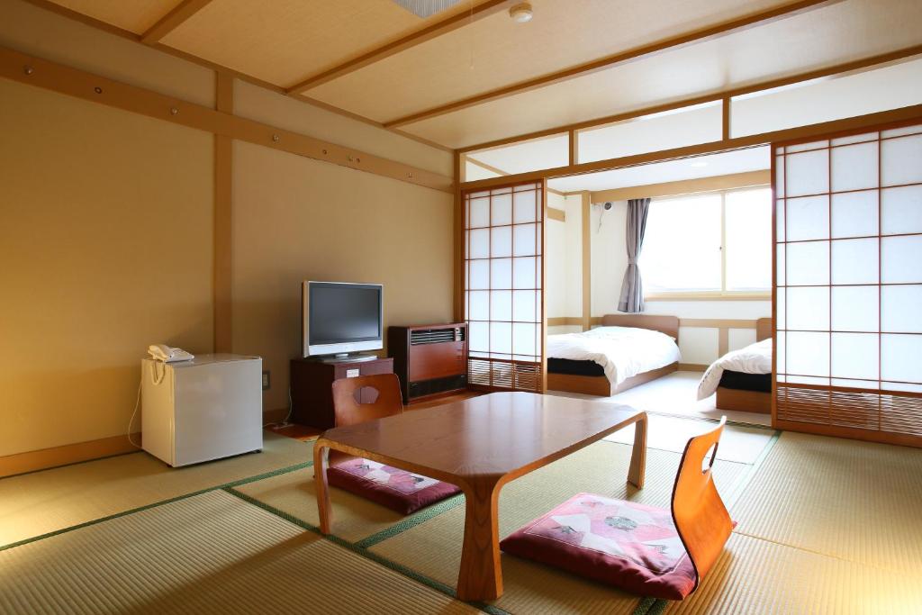 - un salon avec une table basse et une chambre dans l'établissement Shiga Palace Hotel, à Yamanouchi