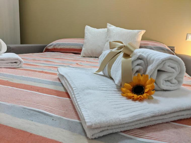 - un lit avec des serviettes et un tournesol dans l'établissement Il Giglio Marino Cilento Residence by ElodeaGroup, à Ascea 27 autres photos