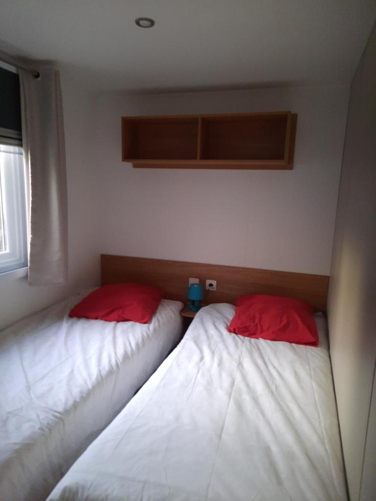 Cette chambre comprend 2 lits avec des oreillers blancs et rouges. dans l'établissement Aquapark -DESS, à Vias
