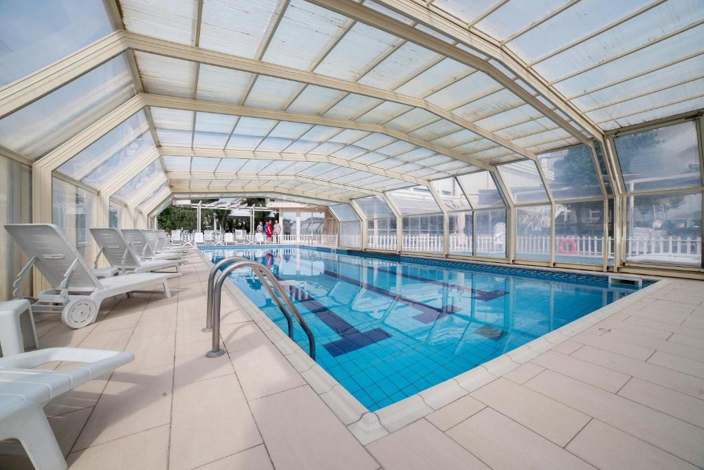 une grande piscine avec un plafond dans l'établissement Hotel Solemare, à Milano Marittima