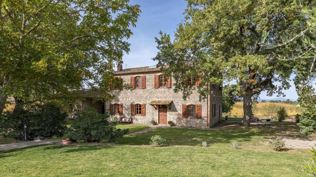 une ancienne maison en pierre avec des arbres devant elle dans l'établissement CASALE LE TRE QUERCE 8&1, Emma Villas, à Orvieto