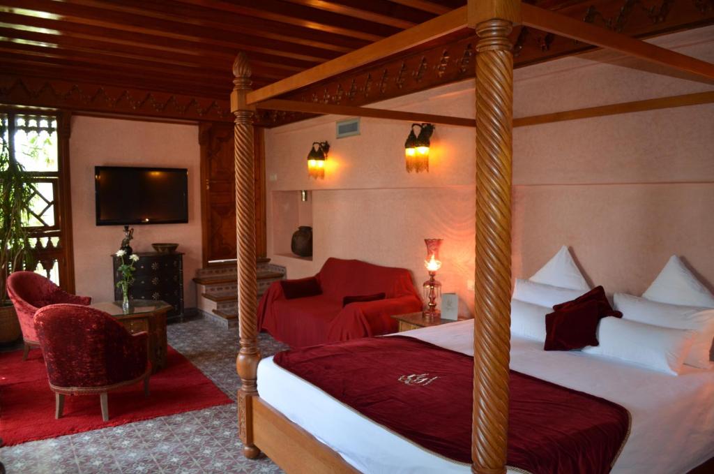 - une chambre avec un lit à baldaquin et une télévision dans l'établissement Riad Flam & Spa, à Marrakech