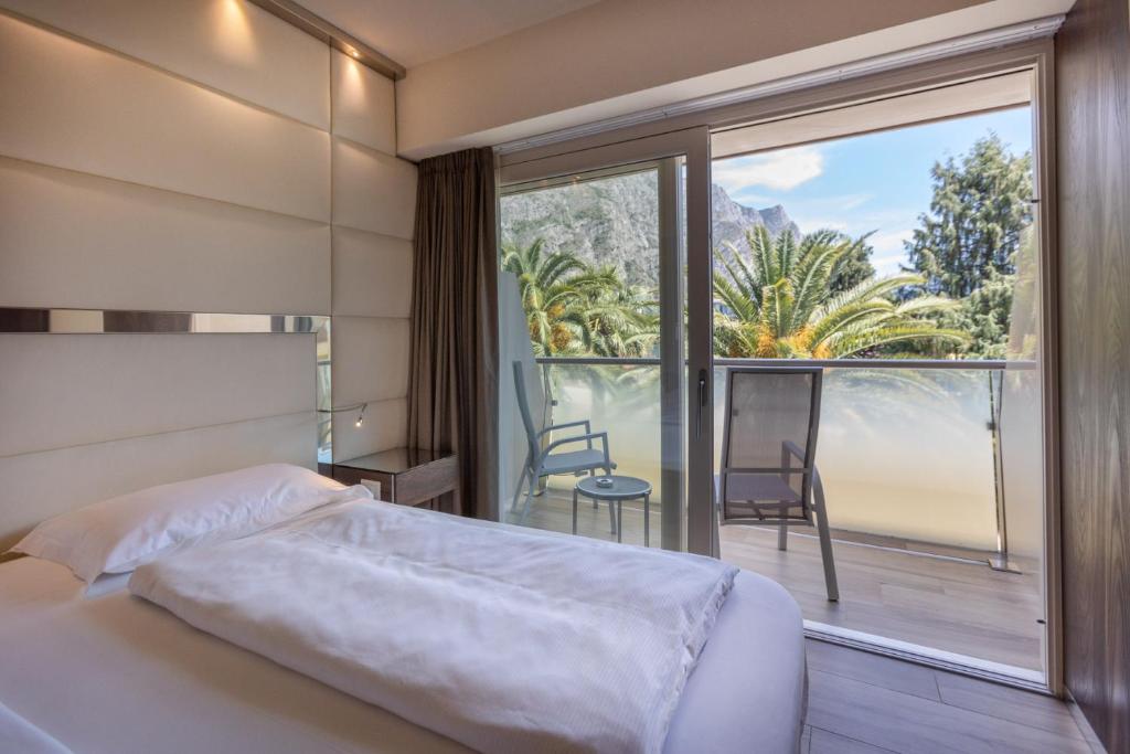 une chambre avec un lit et une grande fenêtre dans l'établissement Hotel Ideal, à Limone sul Garda