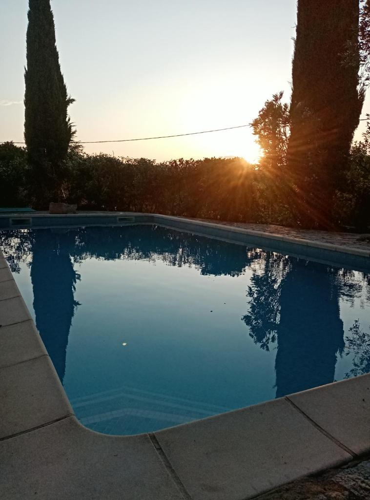 - une piscine avec vue sur le coucher du soleil en arrière-plan dans l'établissement Gîte passiflore, à Frigoulet