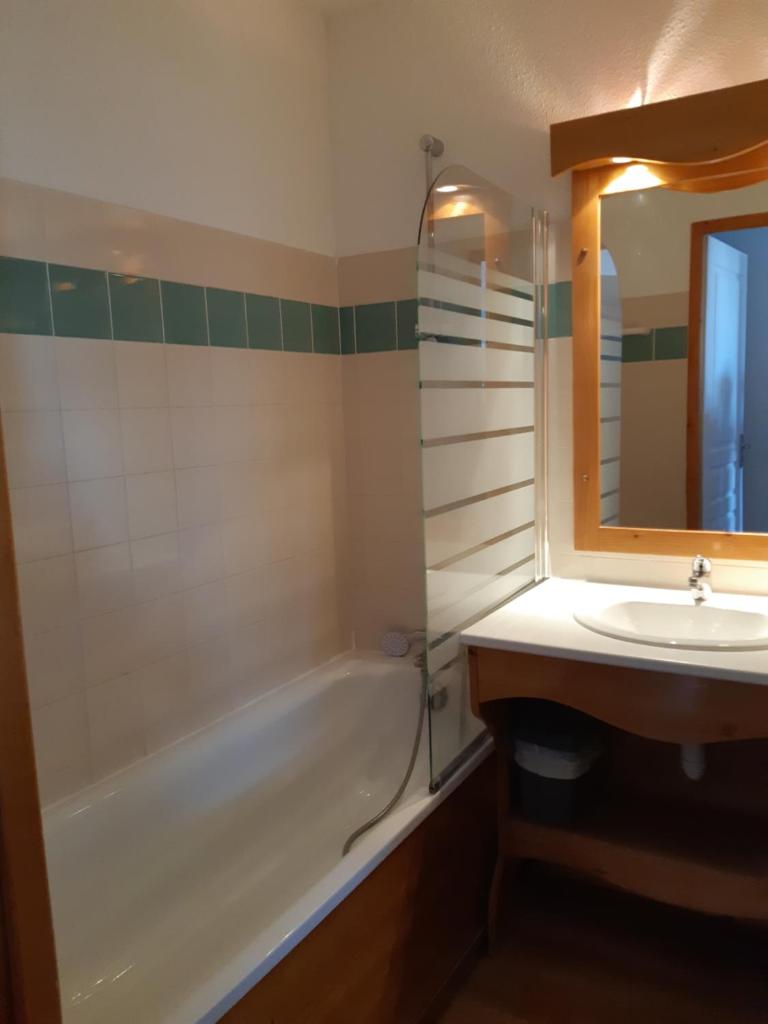 une salle de bain avec un lavabo, une baignoire et un miroir dans l'établissement Chamrousse 1700 - Les Villages du Bachat - Silènes C11 - Classé 3 étoiles, à Chamrousse