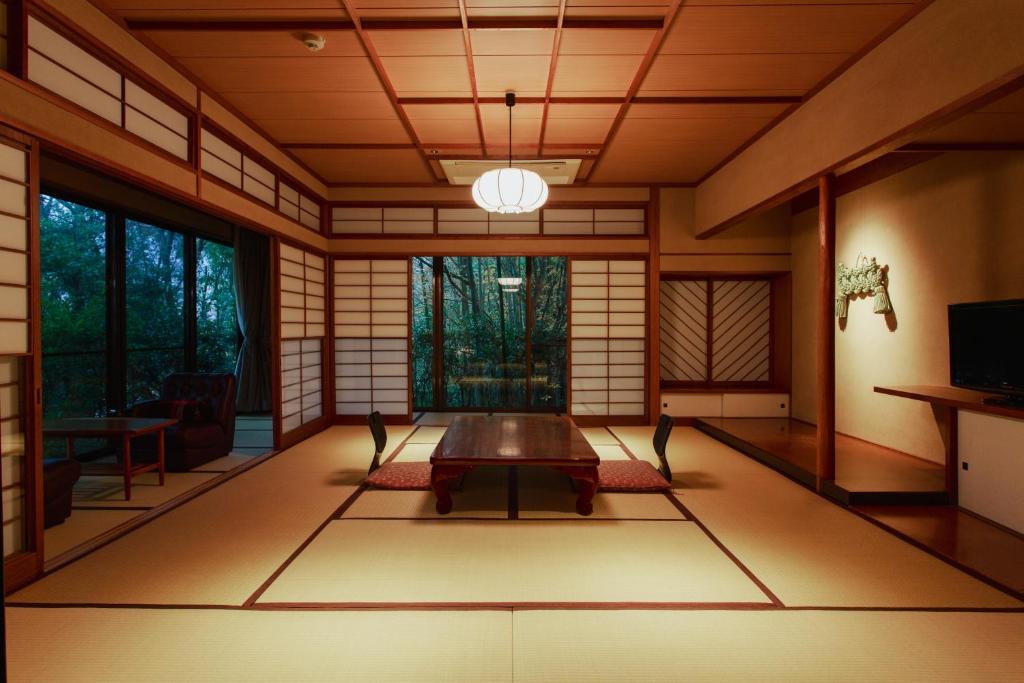 une chambre japonaise avec une table au milieu dans l'établissement Negiya Ryofukaku, à Kobe