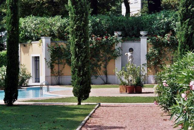 une personne debout dans une cour près d'une piscine dans l'établissement Residence Ville Lago Lugano, à Porto Ceresio