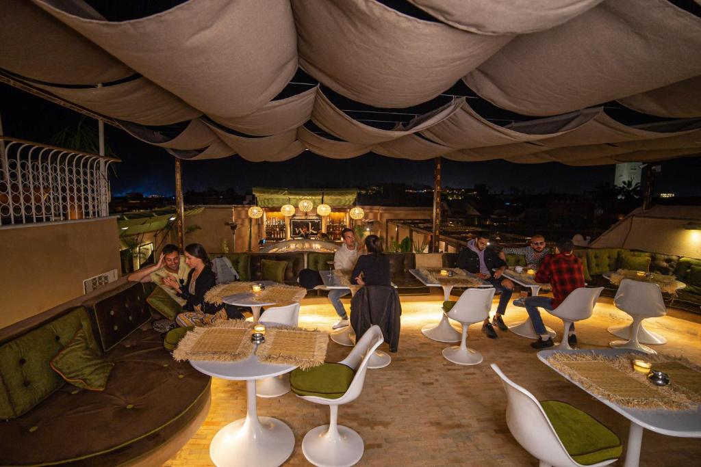 un groupe de personnes assises à des tables dans un restaurant dans l'établissement MAISON MK Adults ONLY - Music Riad, à Marrakech 37 autres photos