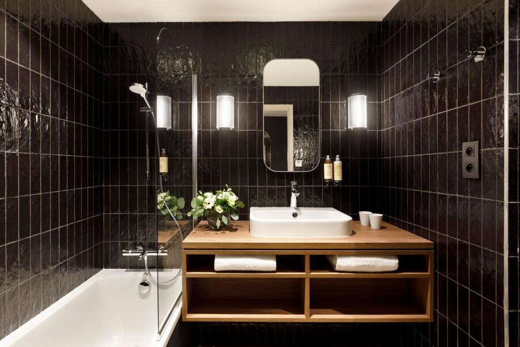 une salle de bain avec un lavabo et une baignoire dans l'établissement Hôtel Marielle, à Val Thorens