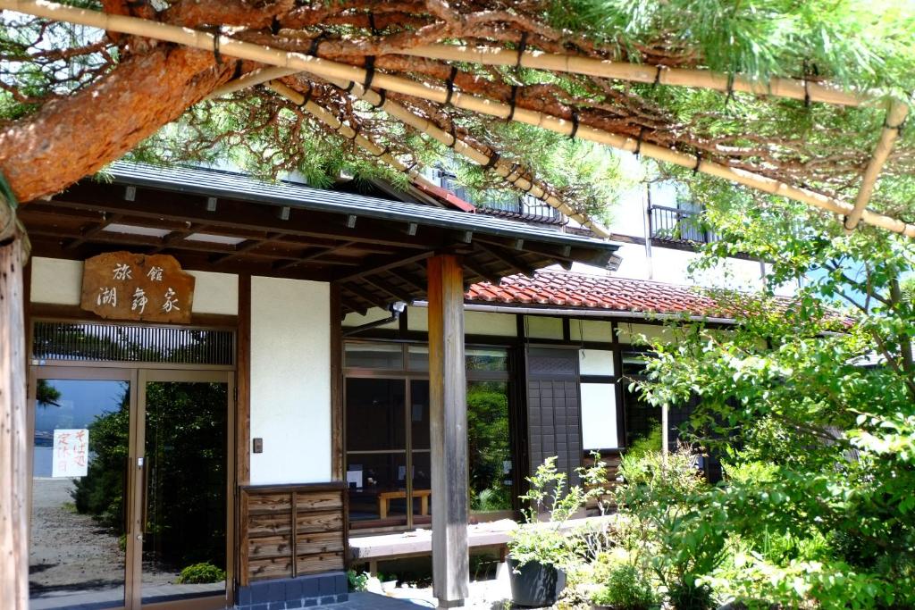 - une vue sur l'extérieur d'un bâtiment avec un arbre dans l'établissement Komaya Ryokan, à Fujikawaguchiko