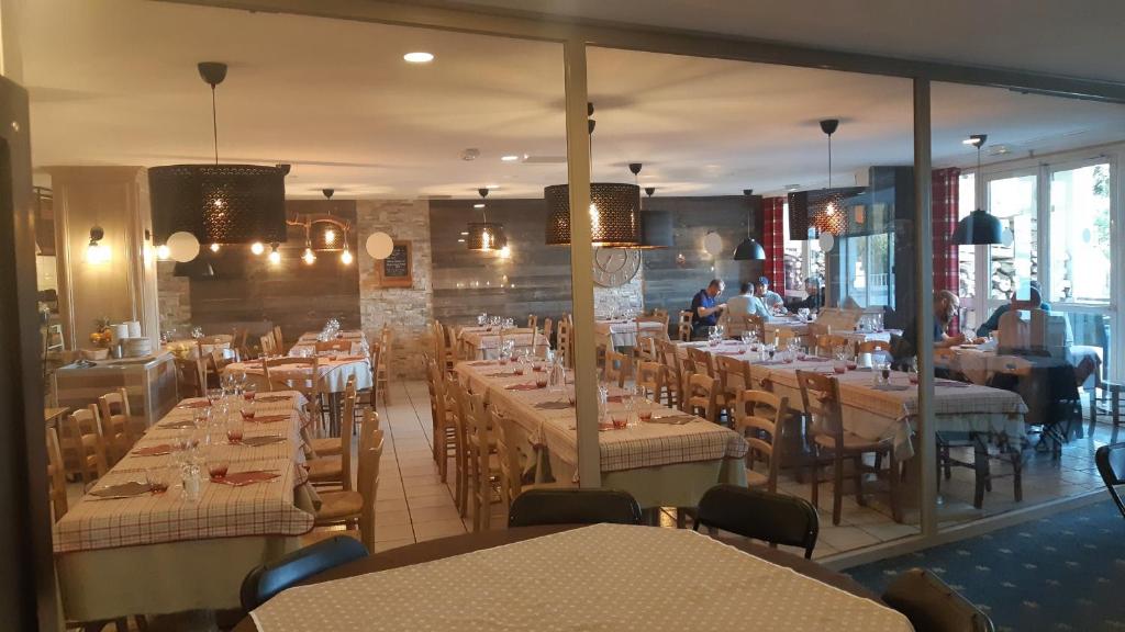 un restaurant avec des tables et des chaises et des personnes en arrière-plan dans l'établissement Superb view+Swim Pool+Smart TV+Netflix+Projector, à Huez