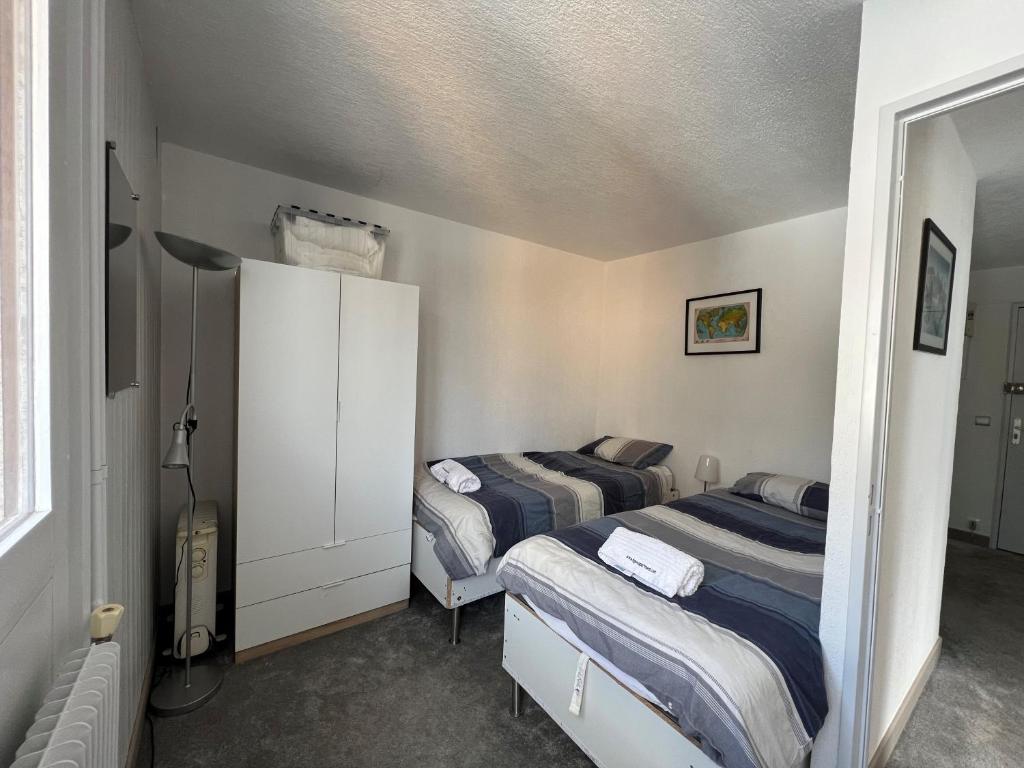 une chambre avec deux lits dans une pièce dans l'établissement Residence Bollin No.21, à Tignes