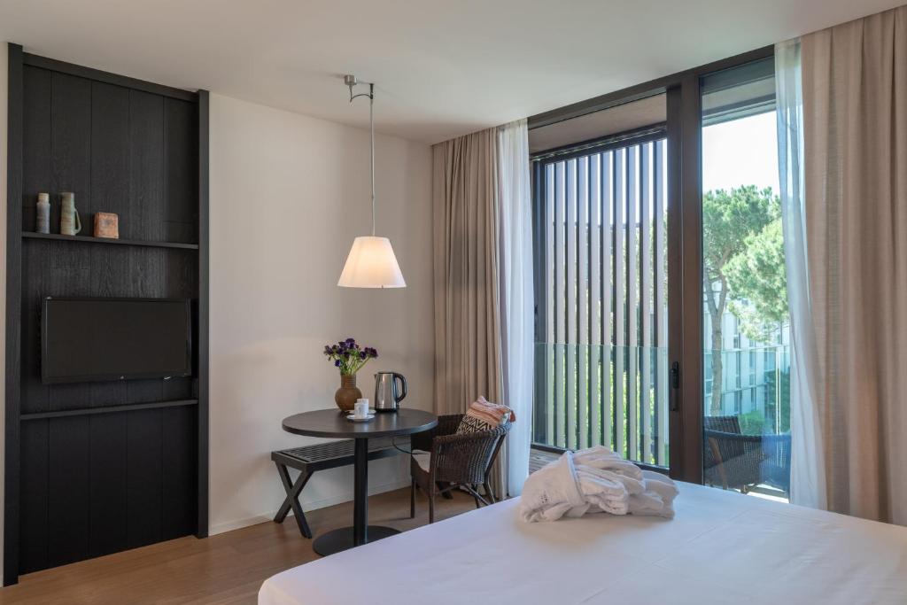 une chambre avec un lit, une table et une fenêtre dans l'établissement MarePineta Resort, à Milano Marittima