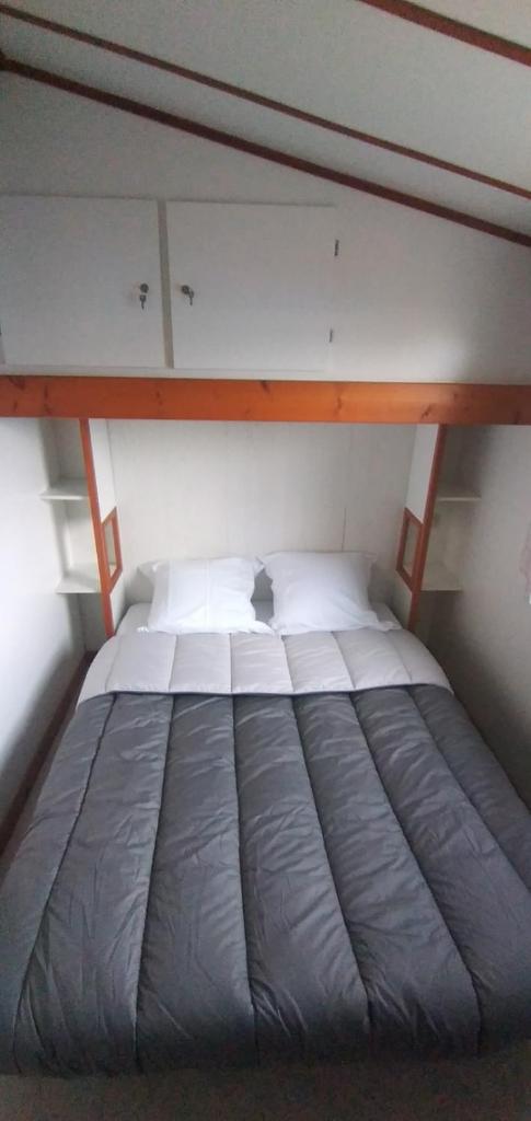 Cette petite chambre comprend un grand lit. dans l'établissement Chalet mobil-home, à Pénestin