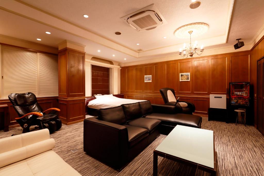 un salon avec un canapé et un lit dans l'établissement HOTEL555 伊豆長岡, à Izunokuni