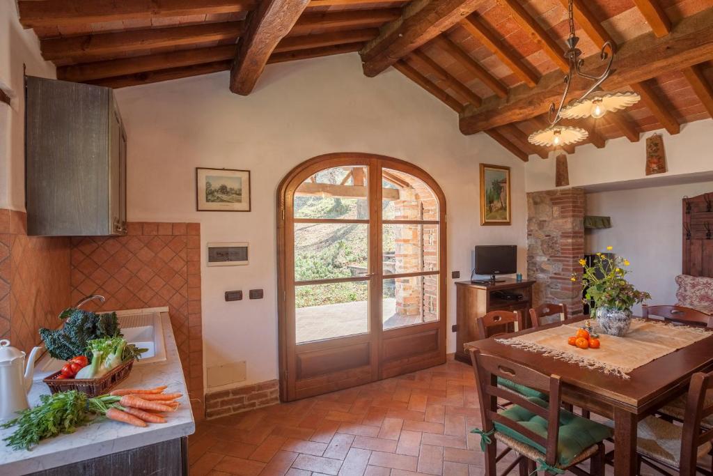 une cuisine avec une porte en bois et une table dans l'établissement Casa nel Bosco, à Sassetta 35 autres photos