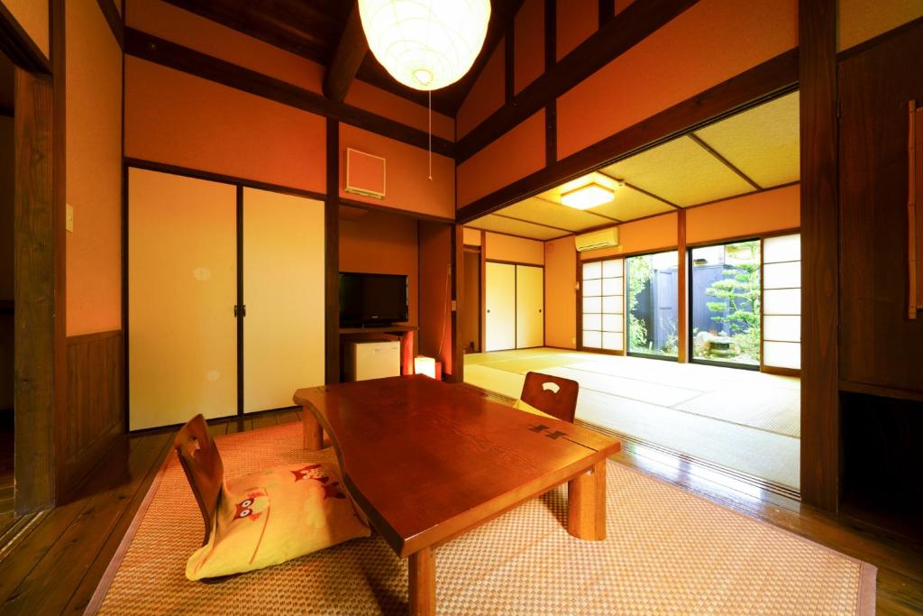 une salle à manger avec une table et des chaises en bois dans l'établissement Yurari Rokumyo, à Yufu