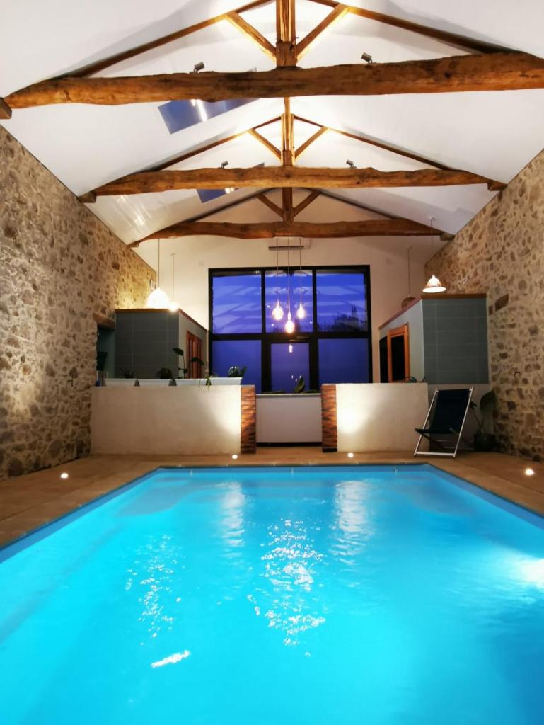 - une grande piscine dans une chambre dotée d'une grande fenêtre dans l'établissement L'Escale du Bocage Piscine couverte chauffée, à La Flocellière