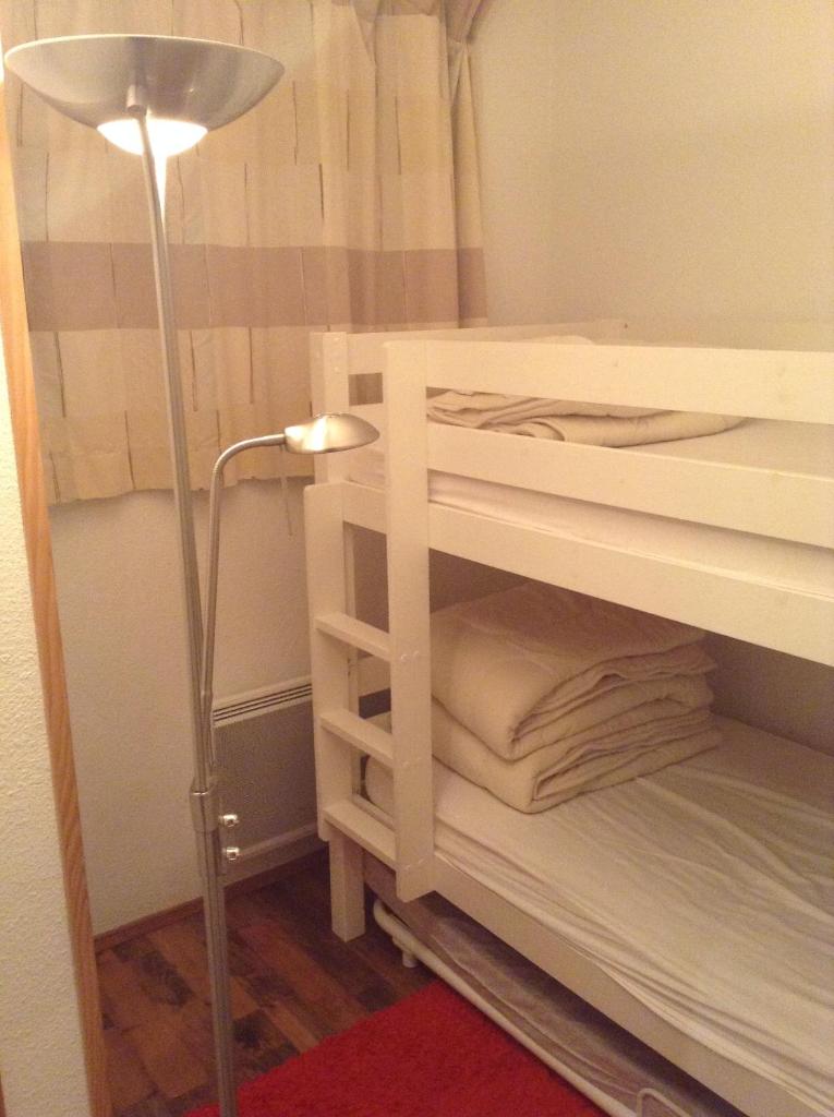 Cette chambre comprend un lit superposé avec une lampe et une lumière. dans l'établissement Résidence Les Mélèzes, à L'Alpe-d'Huez