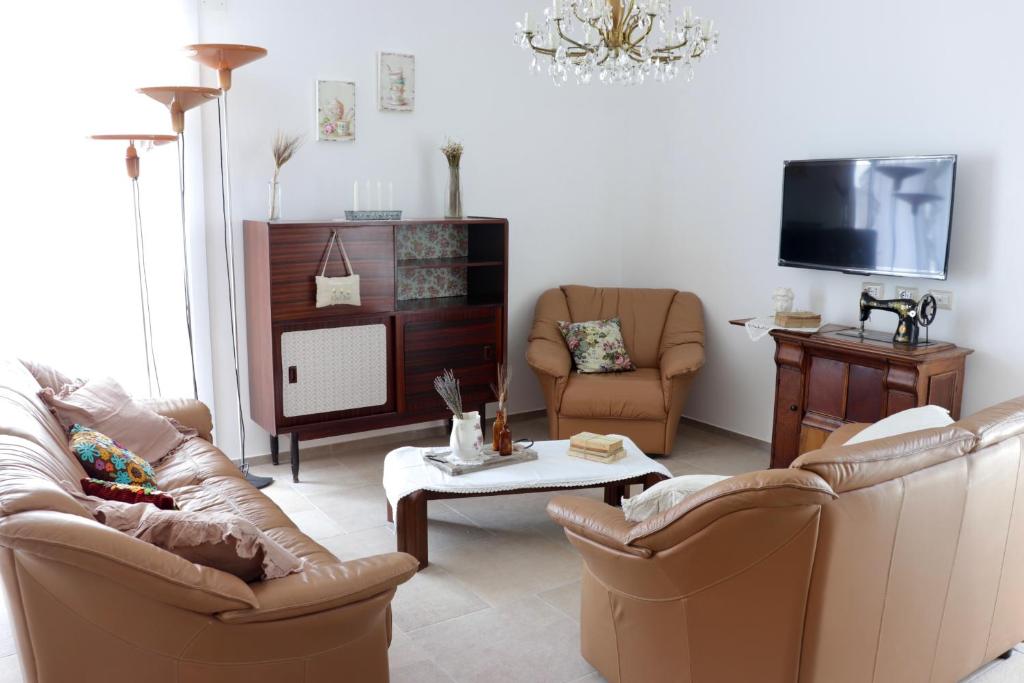 un salon avec deux canapés et une télévision dans l'établissement Charme Ibleo - Casa di campagna in Sicilia, à Raguse 39 autres photos