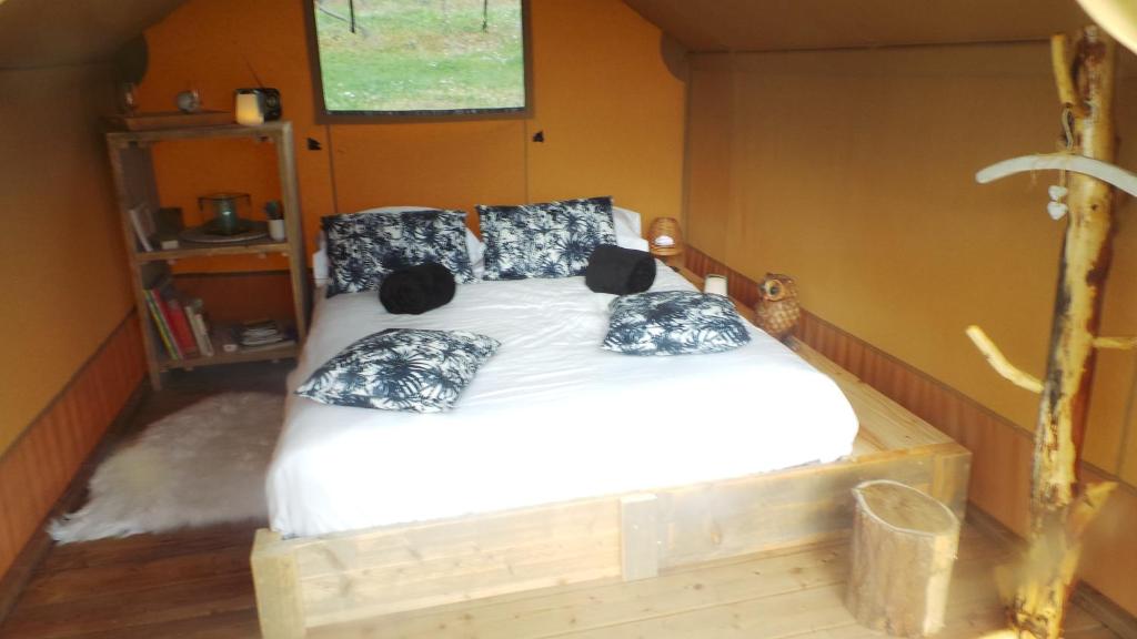une chambre avec un grand lit avec des oreillers dessus dans l'établissement LOVE HORIZON, à Monprimblanc
