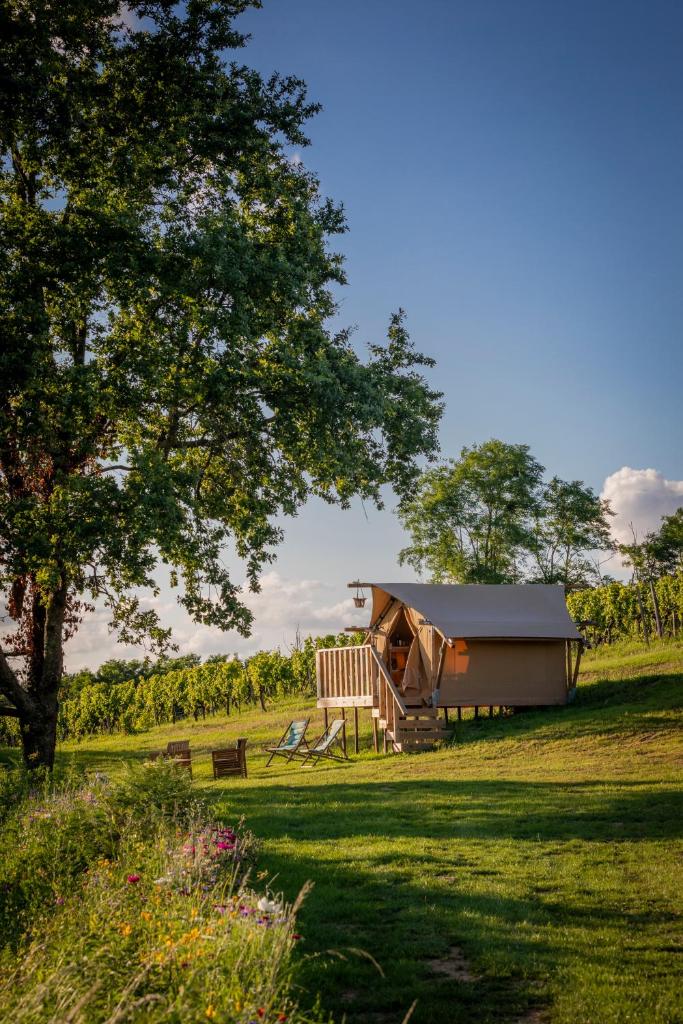 une cabine au milieu d'un champ avec un arbre dans l'établissement LOVE HORIZON, à Monprimblanc 18 autres photos