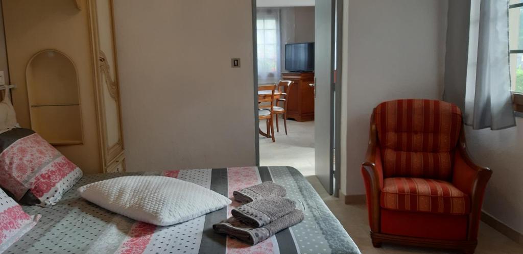 - une chambre avec un lit et une chaise rouge dans l'établissement Gîte, suite d'hote de charme, petit déjeuner compris, à Firmi