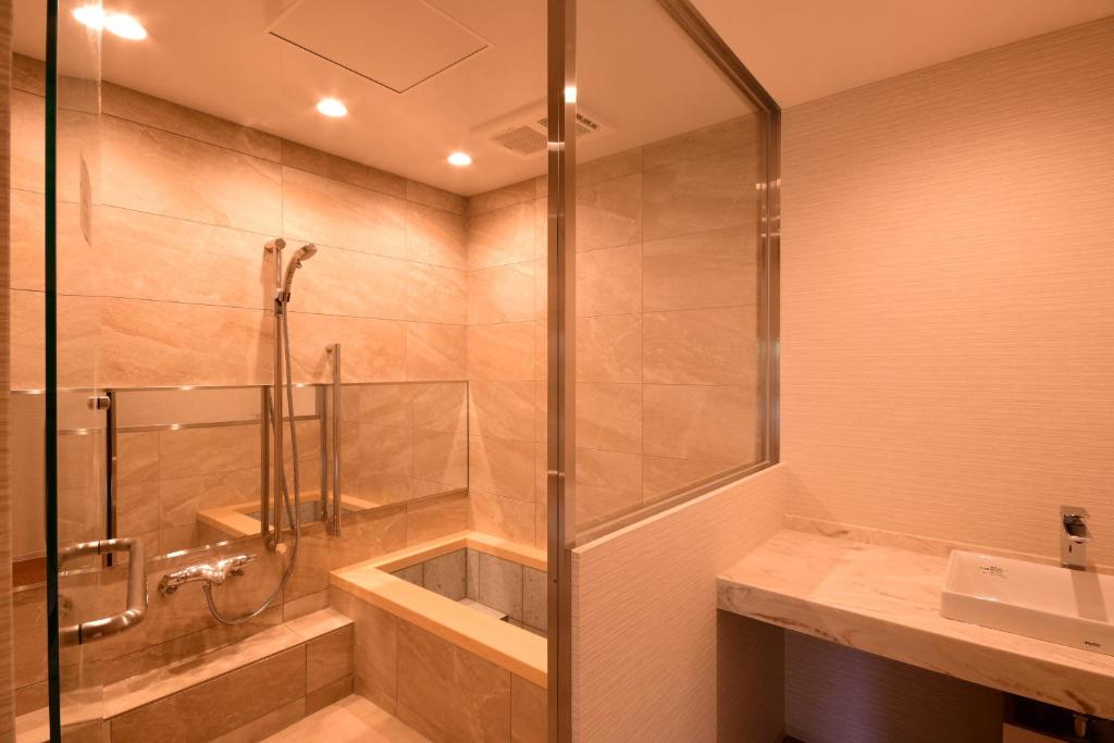 une salle de bain avec douche et lavabo dans l'établissement Koyasan Shukubo Saizenin, à Koyasan