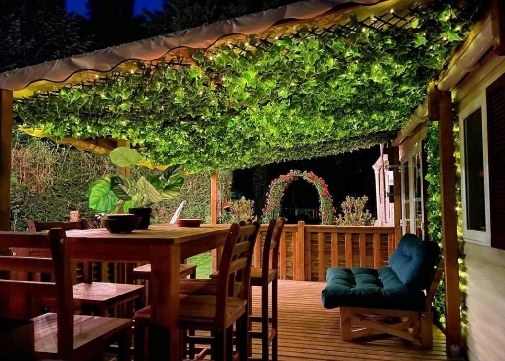 un patio avec une table et des chaises sur une terrasse dans l'établissement Tiki House M-Home-Climatisé - Belle parcelle !, à Saint-Chéron