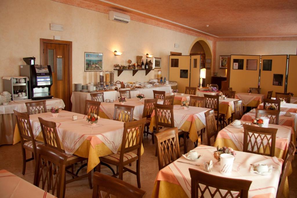 un restaurant avec des tables et des chaises avec une nappe blanche dans l'établissement Hotel Fornaci, à Peschiera del Garda