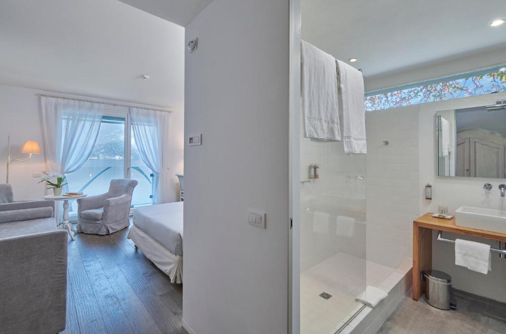 une salle de bain avec une douche, un lit et un lavabo dans l'établissement Hotel Villa Aurora, à Lezzeno