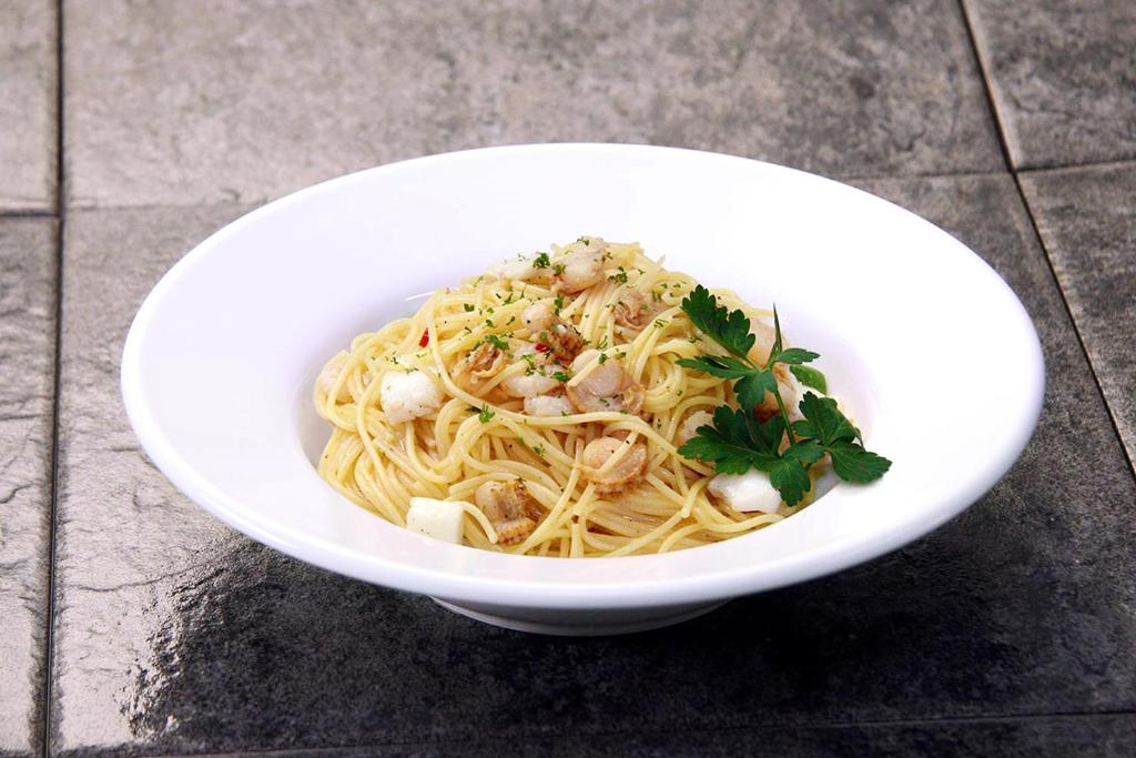 - un bol blanc de pâtes avec des fruits de mer sur une table dans l'établissement 555MOTEL -NUMAZU-, à Numazu