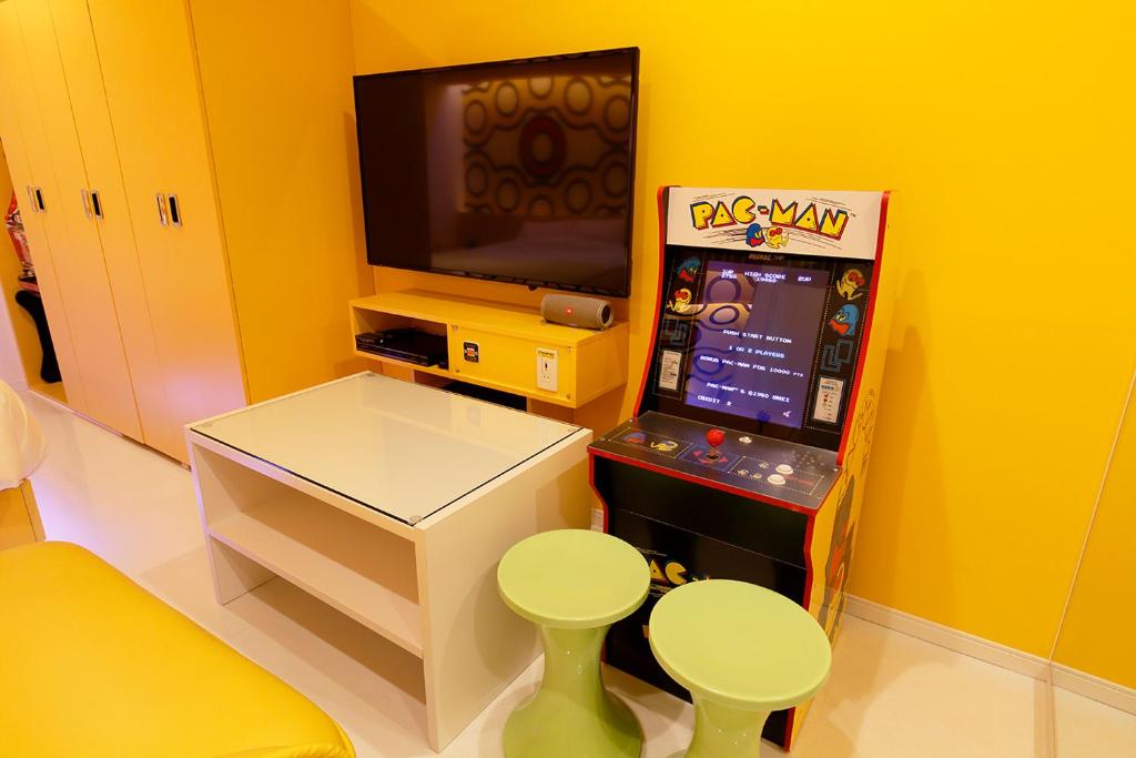 - une salle de jeux avec une machine de jeux vidéo et une télévision dans l'établissement 555MOTEL -NUMAZU-, à Numazu